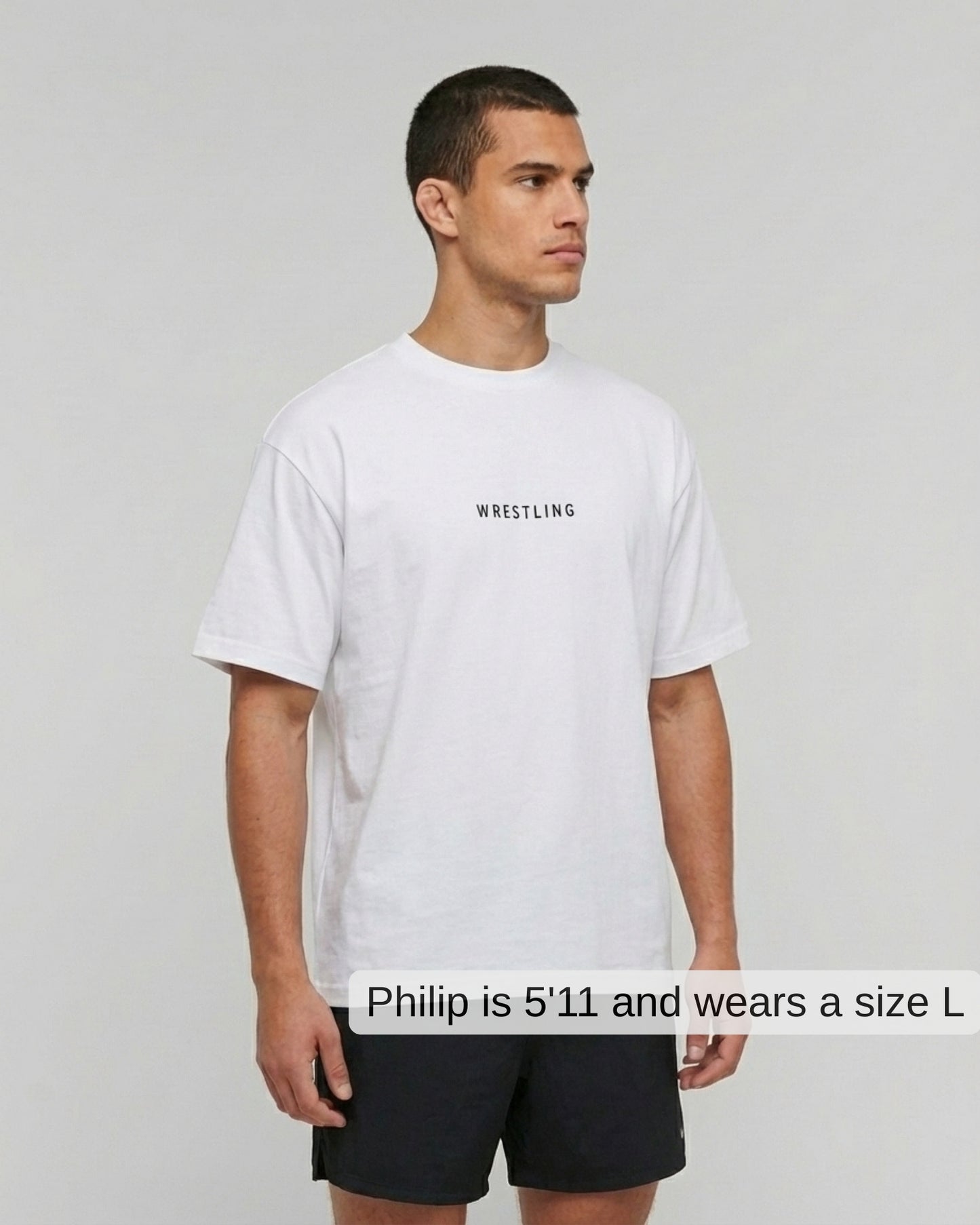 Man wearing a white t-shirt with 'Wrestling' text on a plain background