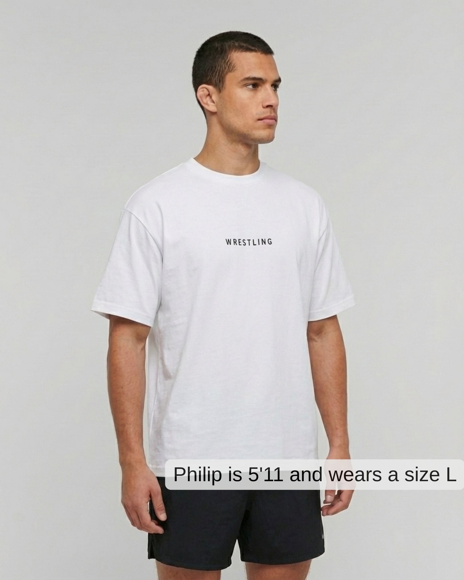 Man wearing a white t-shirt with 'Wrestling' text on a plain background