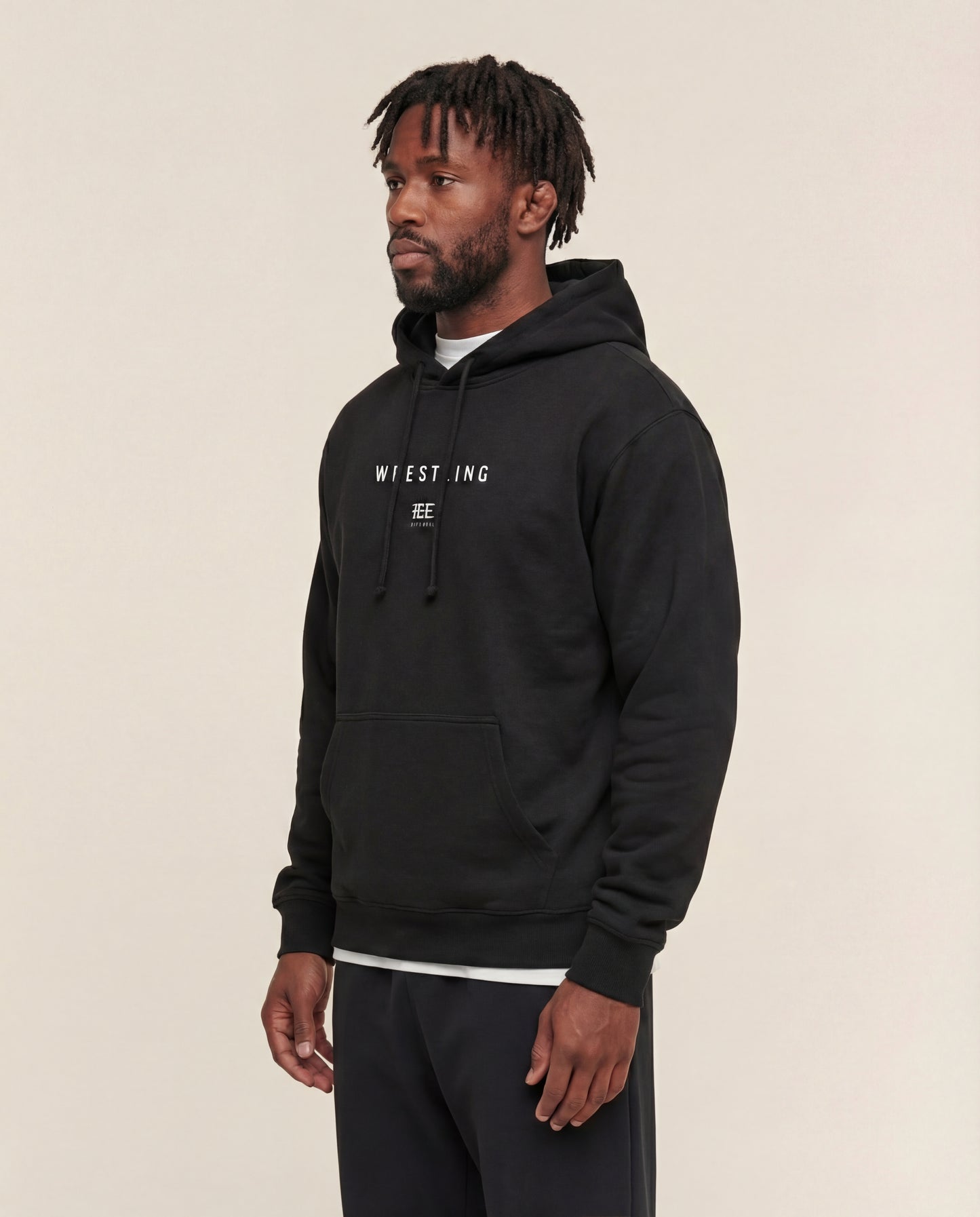 Man wearing a Black hoodie with 'Wrestling' logo on a beige background